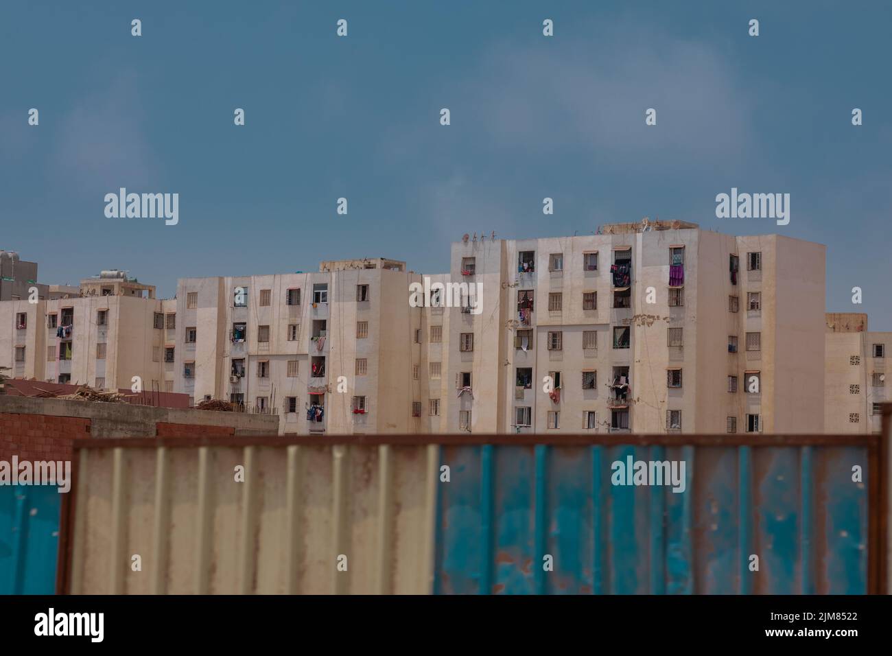 Planches ou murs métalliques pour la construction devant de vieux immeubles d'appartements ou de blocs de ville à Oran, en Algérie. Banque D'Images