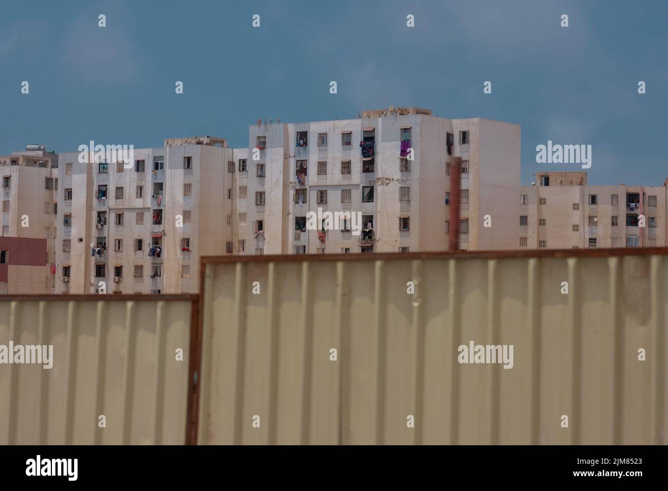 Planches ou murs métalliques pour la construction devant de vieux immeubles d'appartements ou de blocs de ville à Oran, en Algérie. Banque D'Images