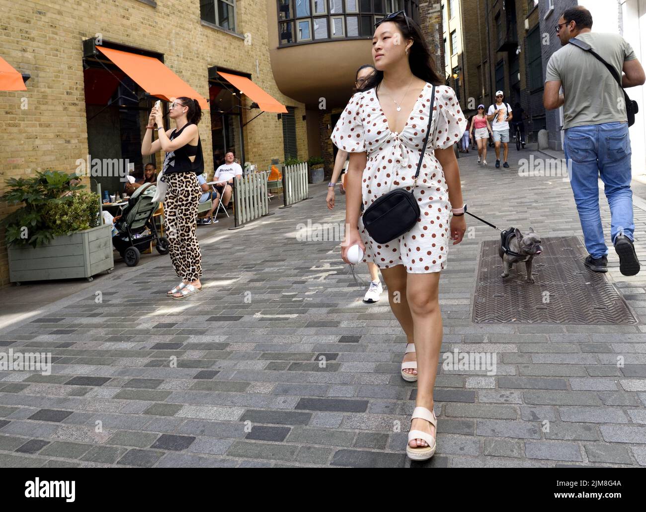 Londres, Angleterre, Royaume-Uni. Jeune femme asiatique marchant dans Clink Street, Southwark Banque D'Images