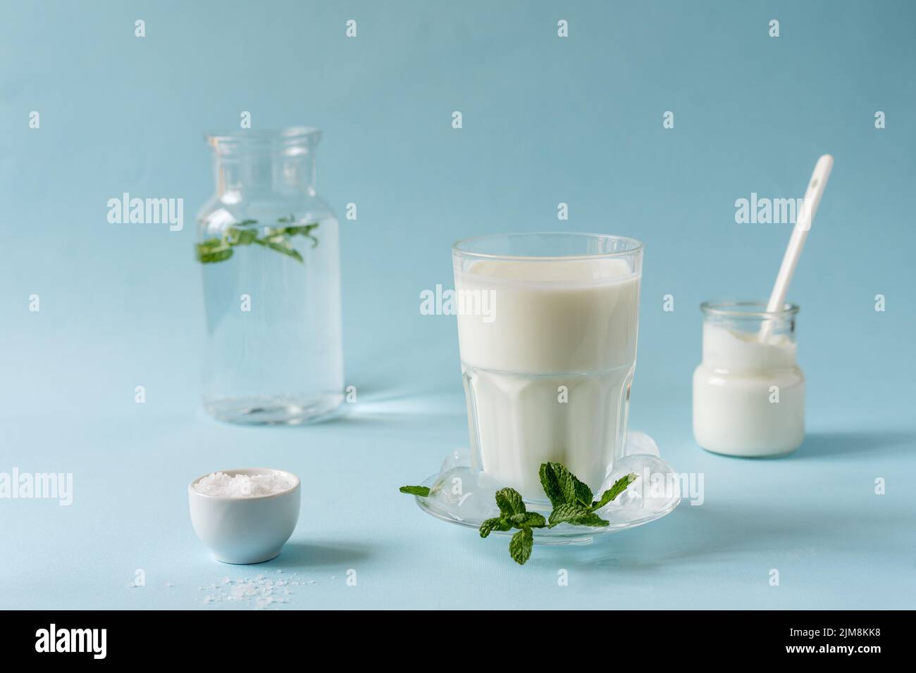 L'ayran ou Doogh est une boisson rafraîchissante populaire du Moyen-Orient, préparée avec du yaourt, de l'eau et du sel. Arrière-plan bleu Banque D'Images