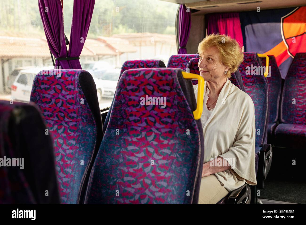 Femme âgée assise dans un bus de voyage et attendant l'excursion Banque D'Images