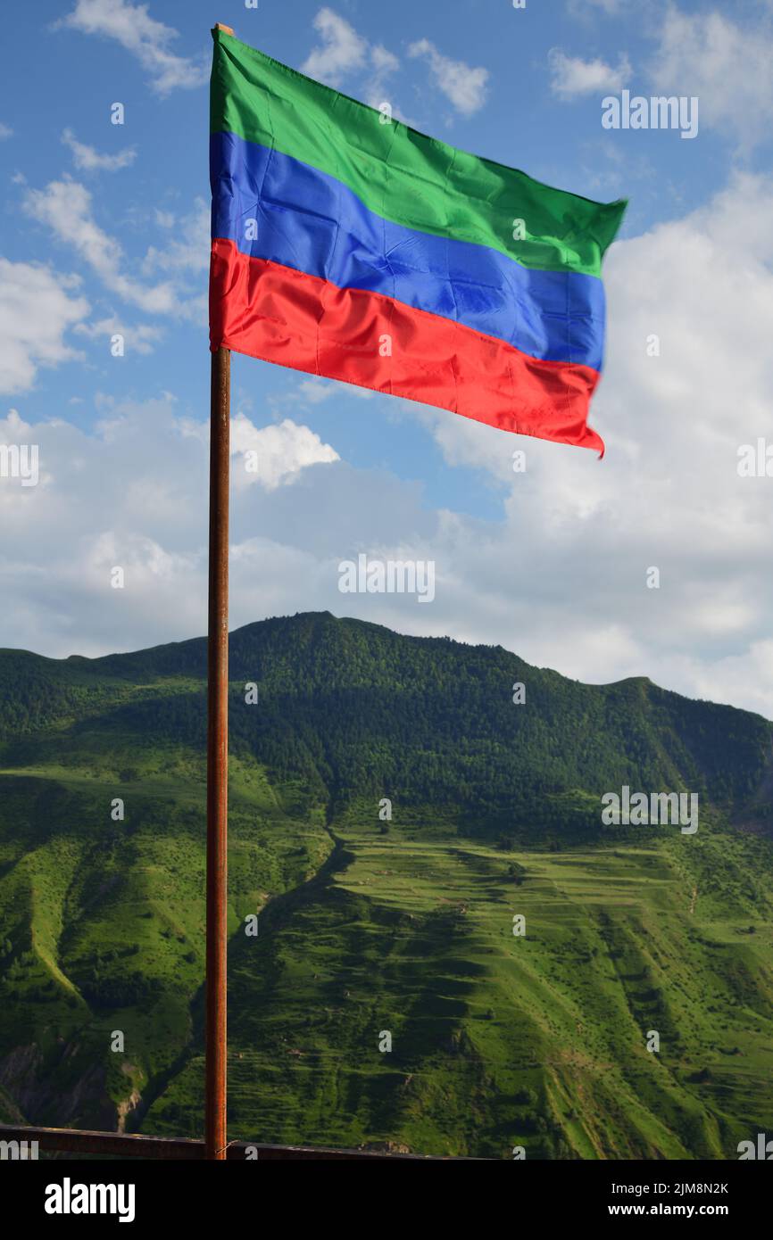 Drapeau tortueux de la République du Dagestan et des montagnes du Caucase en arrière-plan. Russie Banque D'Images