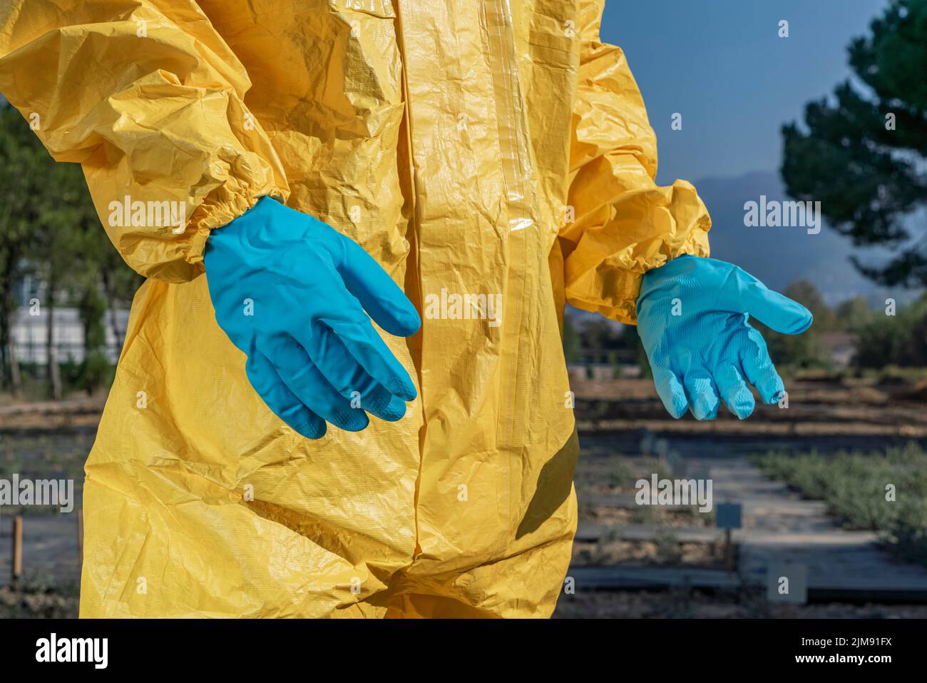 Mise au point sélective de gants de protection bleus et de combinaisons jaunes. Banque D'Images