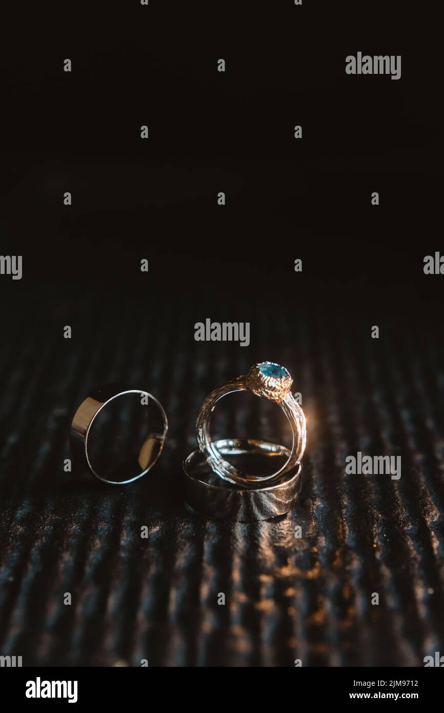 Anneaux de mariage sur une ancienne surface en bois, style rustique. Gros plan de deux anneaux de mariage en or et anneau d'engagement pour un mariage. Banque D'Images