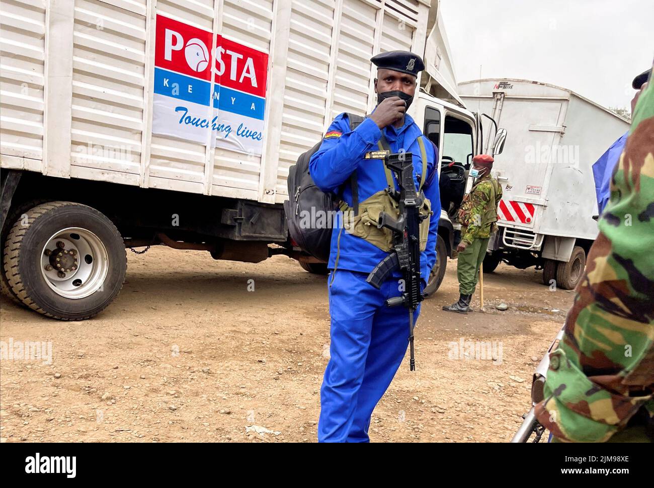 Les policiers se tiennent en garde tandis que les travailleurs se préparent à envoyer du matériel électoral présidentiel dans un entrepôt de la Commission électorale et de délimitation des circonscriptions indépendantes (CBEI) avant les prochaines élections générales à Nairobi, au Kenya, en 5 août 2022. REUTERS/Thomas Mukoya Banque D'Images
