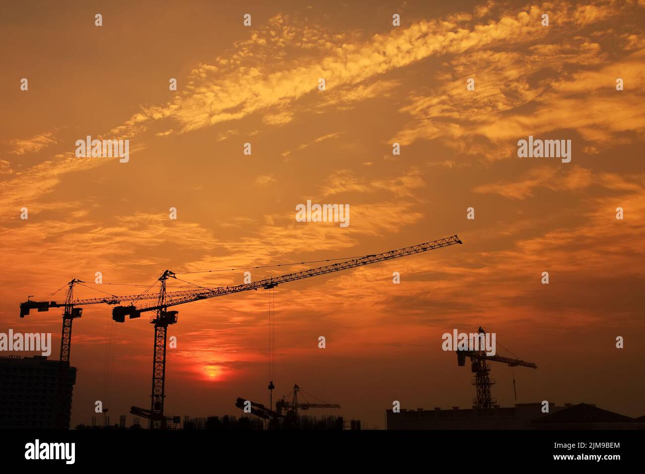 Grue de construction industrielle contre le coucher du soleil dans la ville de Dubaï Banque D'Images