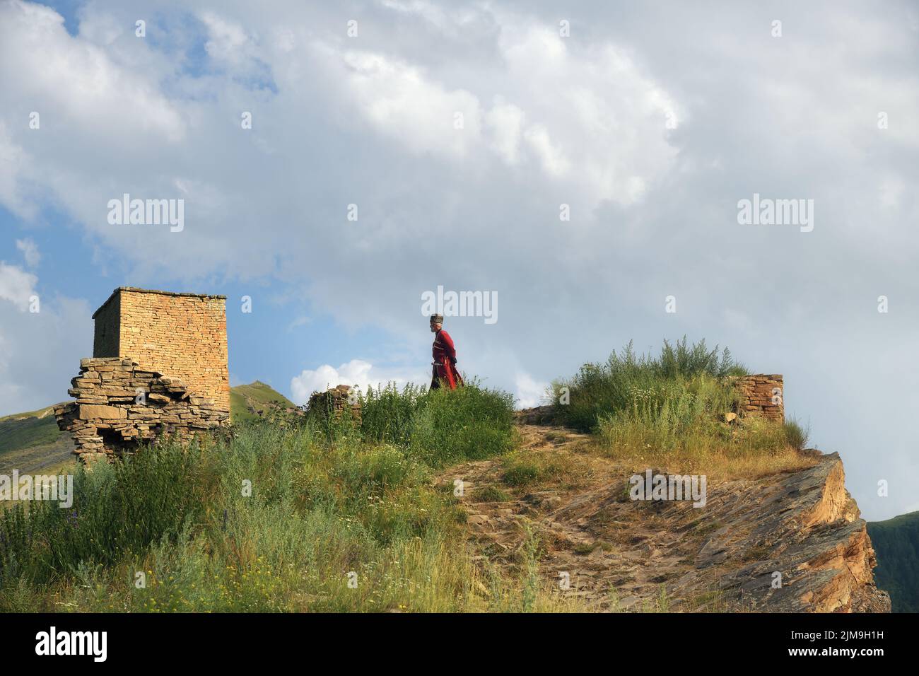 Dagestan, Russie - 21 juillet, 2022: Homme local dans la tradition nationale robe reste contre tour de bataille dans le village de Goor Banque D'Images