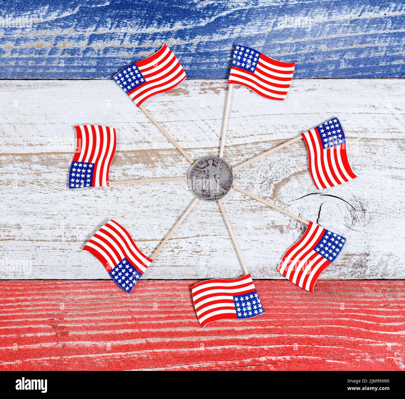 Petits drapeaux des États-Unis en formation de cercle autour de la pièce Liberty sur des panneaux rustiques avec des couleurs nationales Banque D'Images