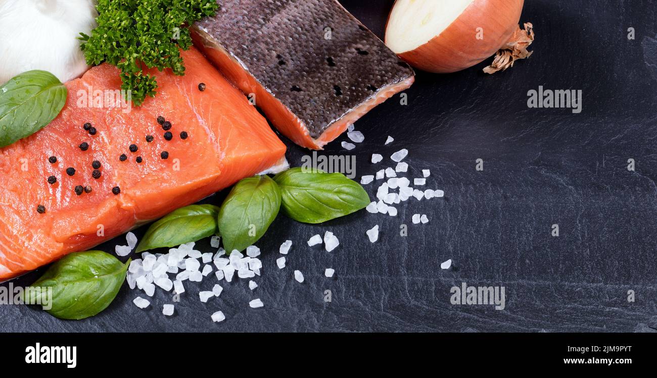 Filet de saumon sauvage et herbes fraîches sur pierre noire Banque D'Images