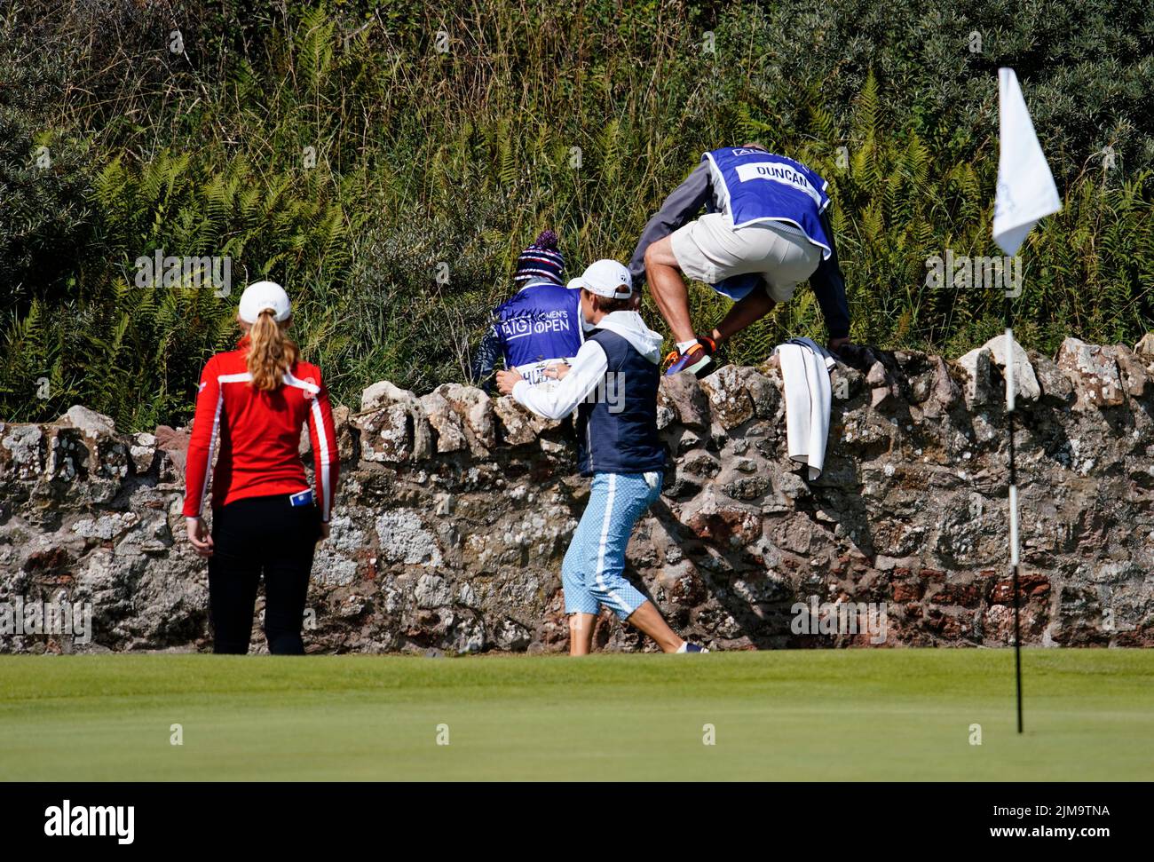 Gullane, Écosse, Royaume-Uni. 5th août 2022. Deuxième manche du championnat de golf AIG Women’s Open à Muirfield dans East Lothian. Pic; les caddies grimpent le mur à côté du fairway 2nd pour rechercher le ballon perdu. Iain Masterton/Alay Live News Banque D'Images