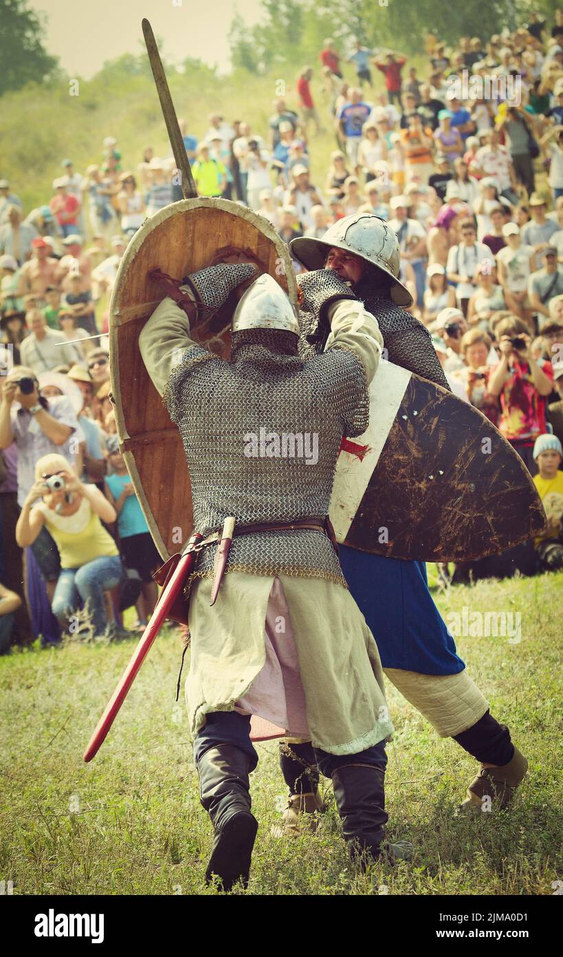 Samara, Russie, le festival de la reconstruction historique Russie antique 11-13 ans - 11 août 2013: Bataille de deux guerriers en casques et chaîne de courrier, épées et boucliers au festival de la reconstruction historique sur le terrain avec le public Banque D'Images