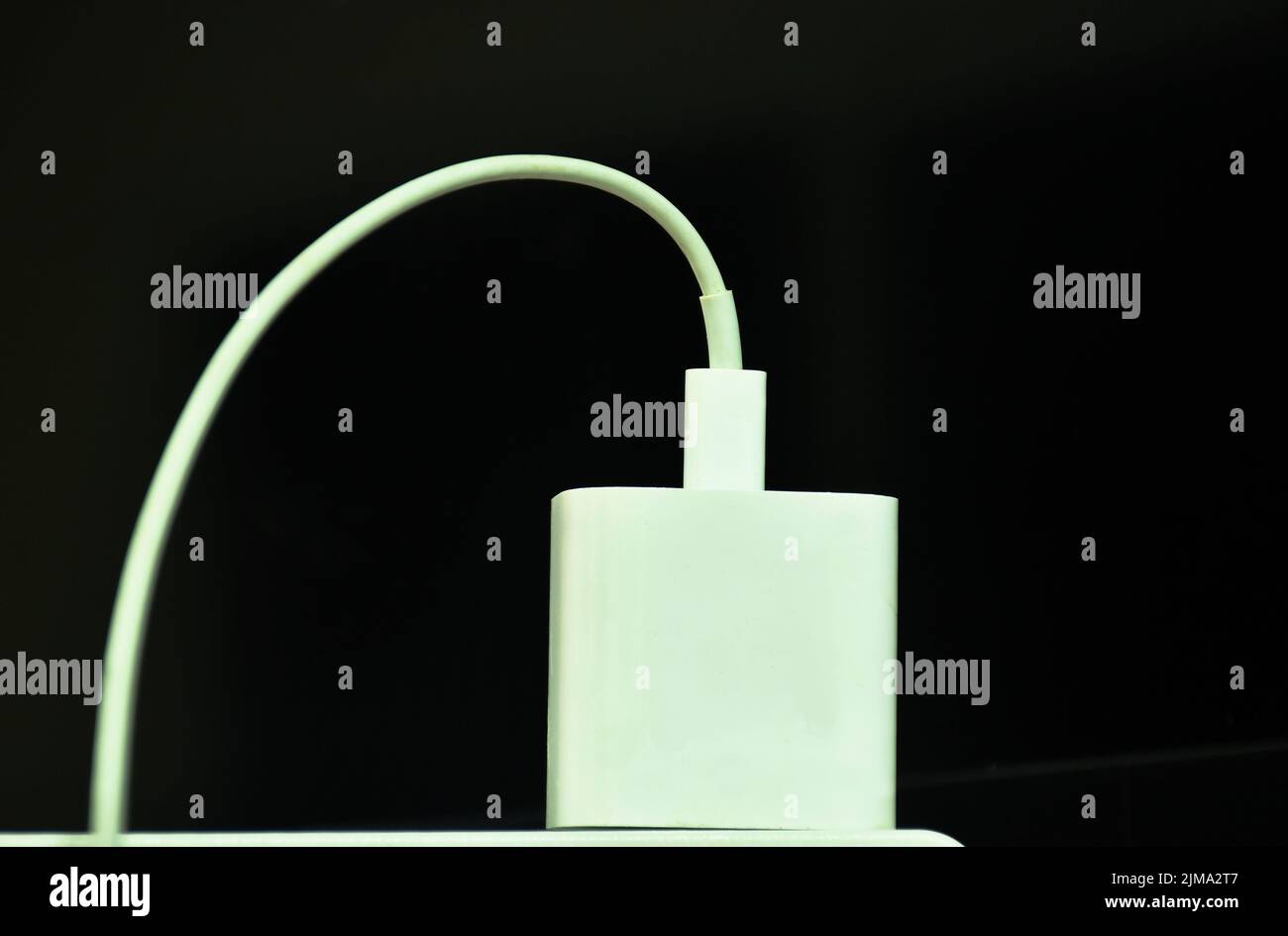 chargeur de téléphone portable blanc avec prise sur fond noir Banque D'Images