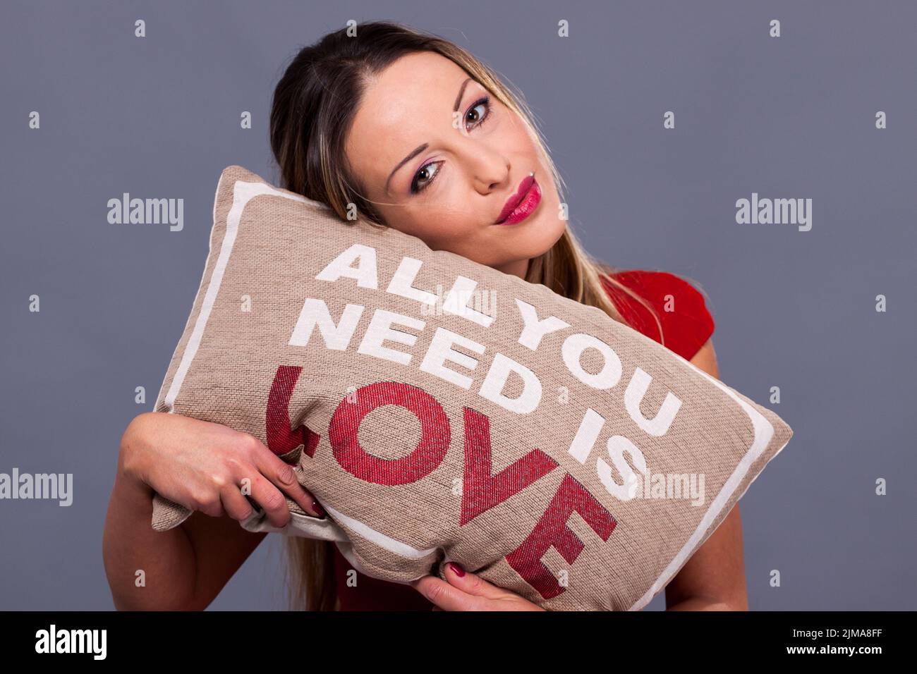 Message de Saint Valentin avec oreiller tout ce qu'il vous faut, c'est l'amour, femme en robe rouge Banque D'Images