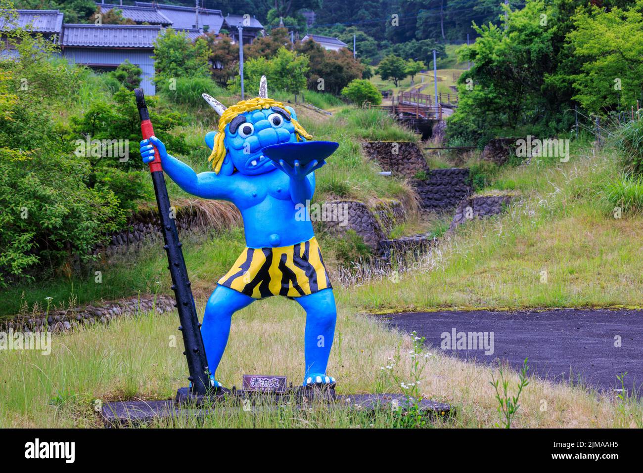 Statue de démon bleu tenant un bol et un club dans un petit village de montagne japonais Banque D'Images
