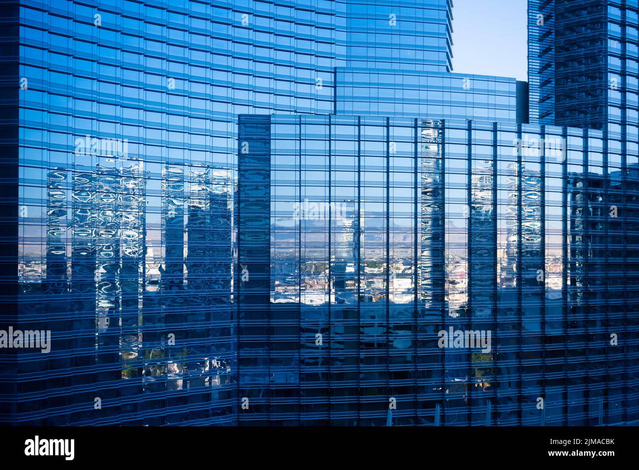 Gratte-ciel et ciel bleu se reflète dans une façade en verre d'un gratte-ciel moderne. Banque D'Images