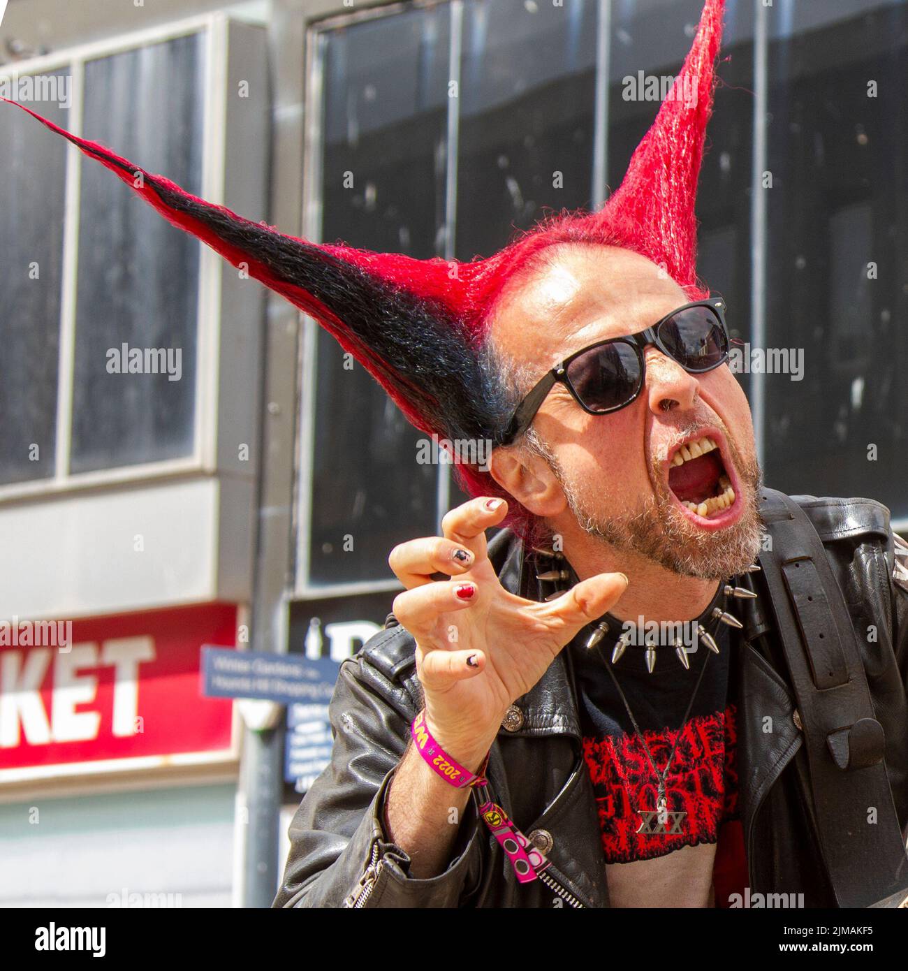 Little John Guelfi un bucker, artiste musical, chanteur rock et musicien de rue de métal à Blackpool, Lancashire, Royaume-Uni. Août 2022. La sous-culture punk, les idéologies, la mode, avec des coiffures mohican teints et la coloration au festival Punk Rebellion aux jardins d'hiver. Une protestation contre les attitudes et les comportements conventionnels, un choc des cultures anti-establishment, des mohawks, des épingles de sécurité et une charge d'attitude à la ville de bord de mer tandis que les punks participant au festival annuel de musique rock Rebellion aux jardins d'hiver se côtoient avec les vacanciers traditionnels. Banque D'Images