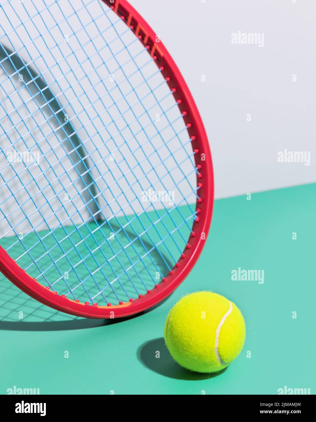 Composition de tennis avec raquette de tennis rouge et jaune, balle de tennis sur fond bleu. Compétition de tennis. Mise au point sélective, gros plan Banque D'Images