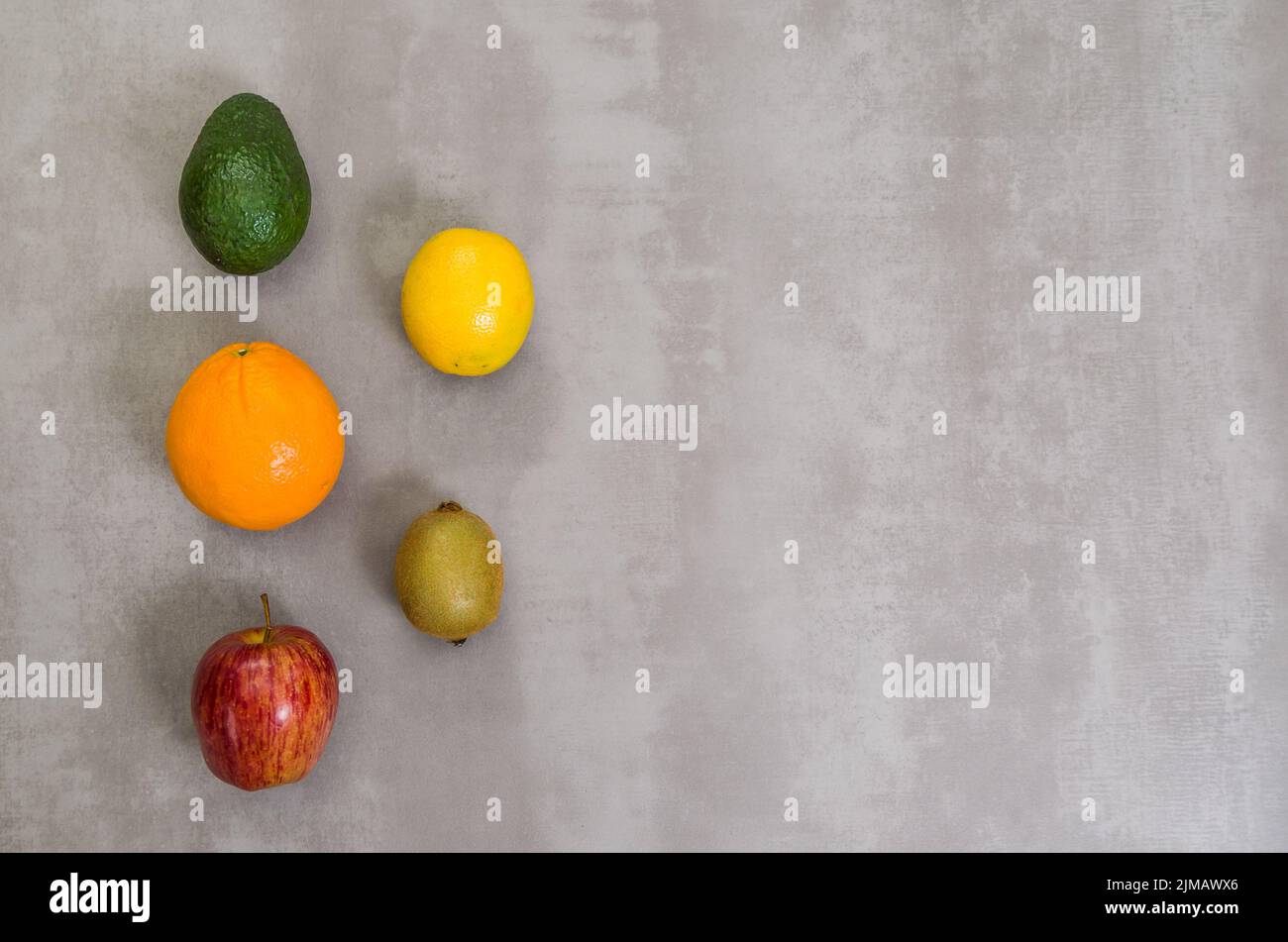 Grand concept de la saine alimentation, divers fruits sur fond gris, béton poli. Orange, Pomme, kiwi, citron. Banque D'Images