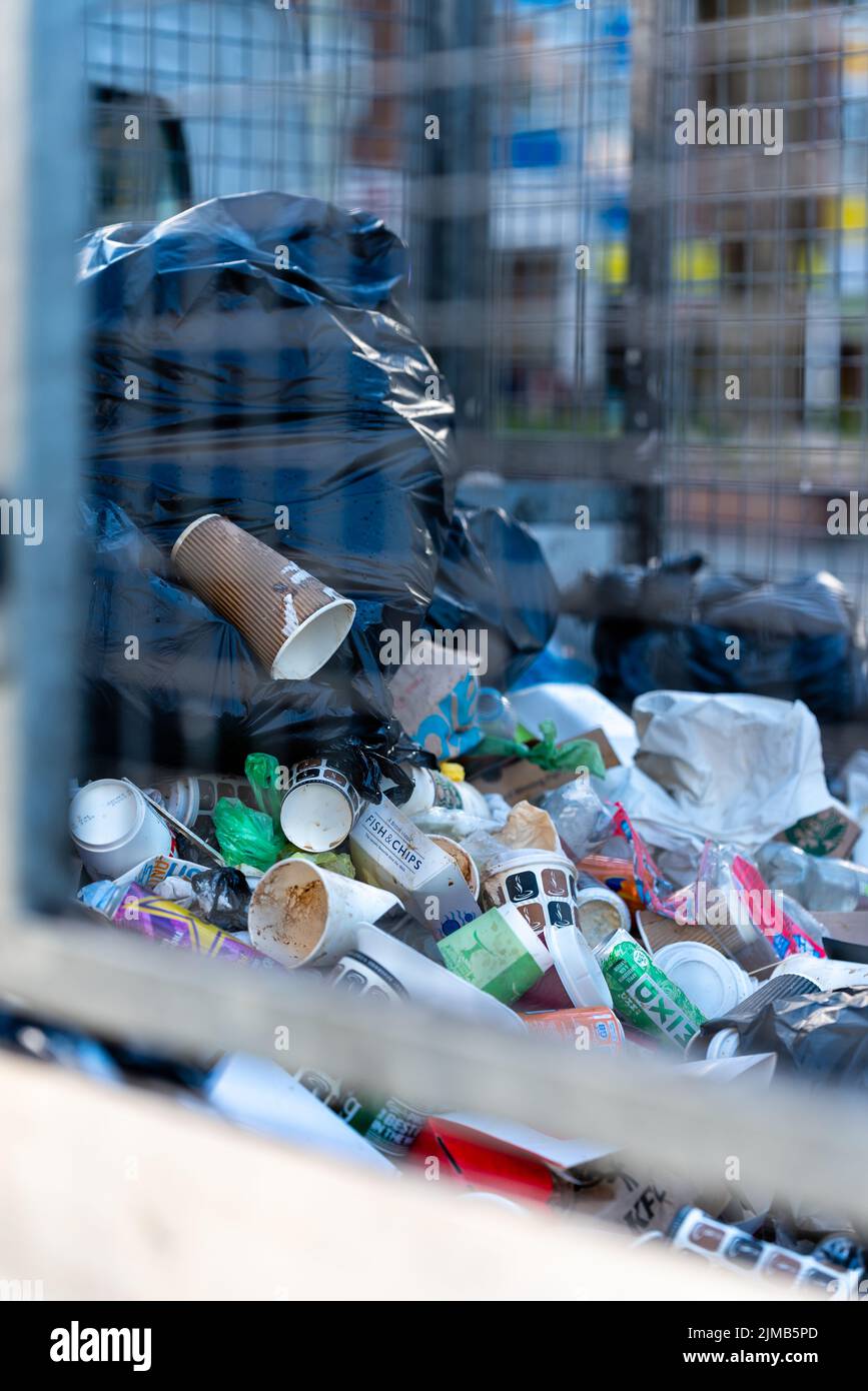 Un gros plan vertical de déchets collectés dans les poubelles publiques d'une zone urbaine très fréquentée Banque D'Images