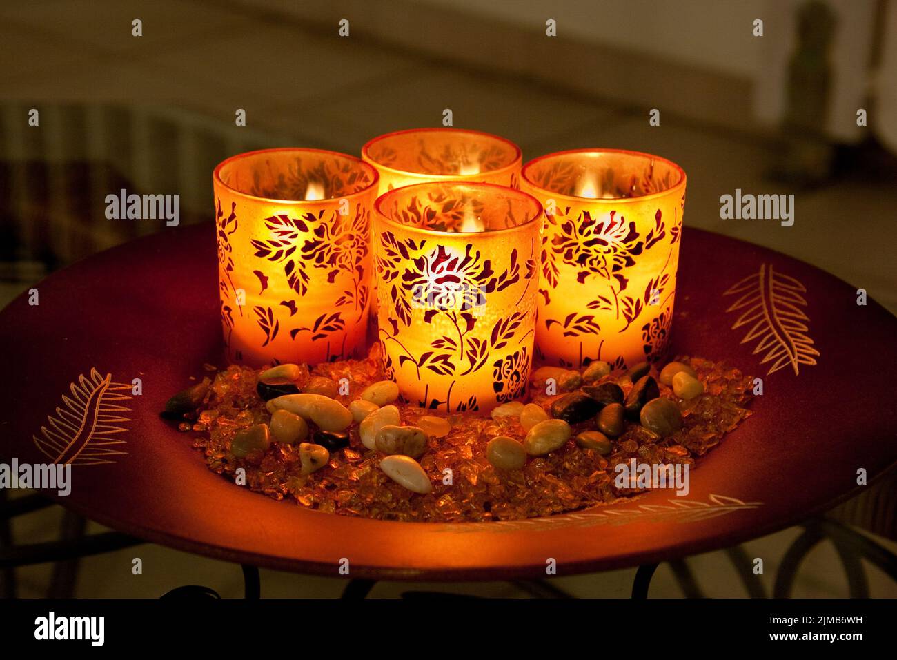 Bougies allumées dans des verres décorés sur l'assiette - vue latérale Banque D'Images