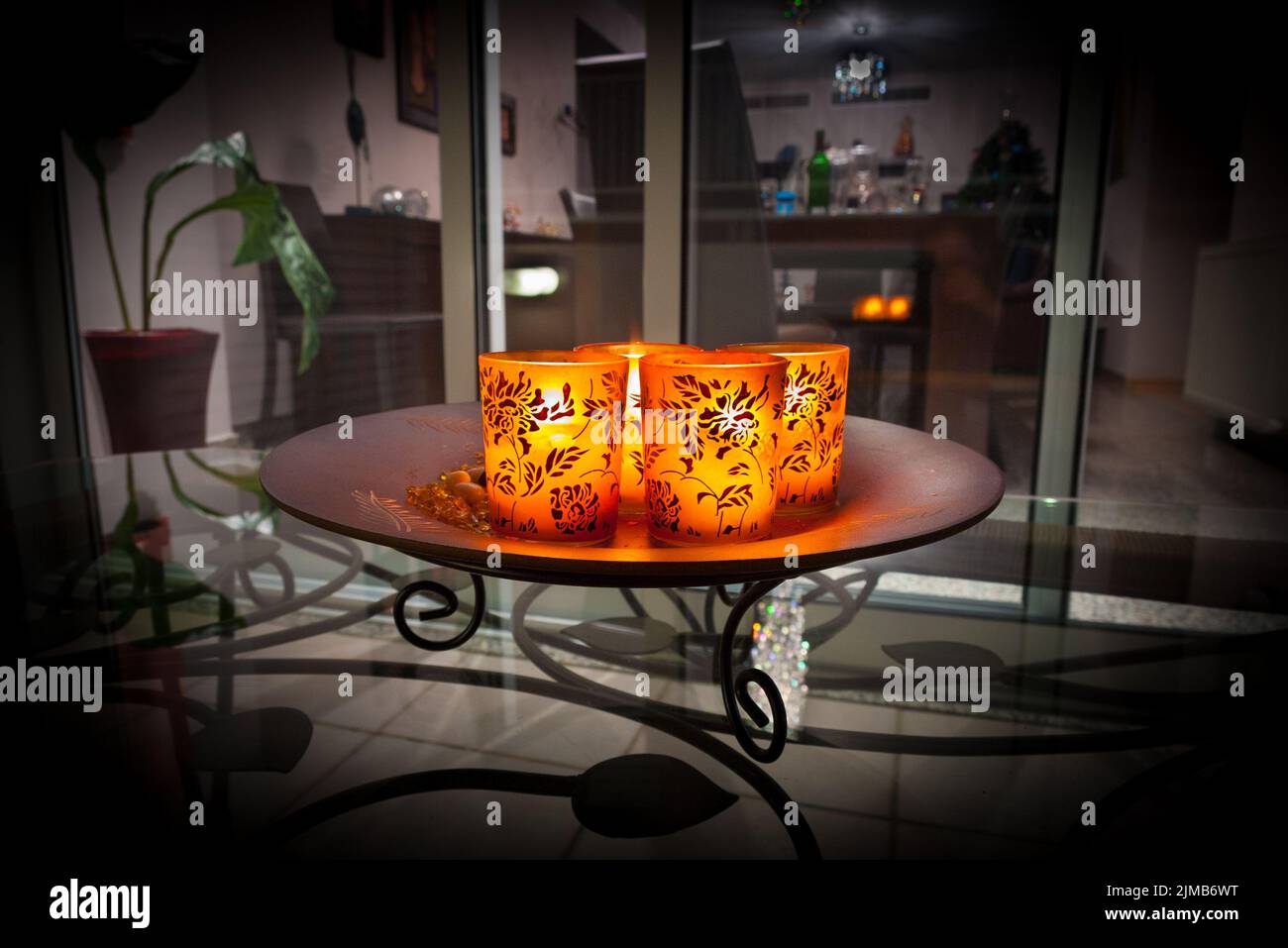 Bougies allumées dans verres décorés sur l'assiette Banque D'Images