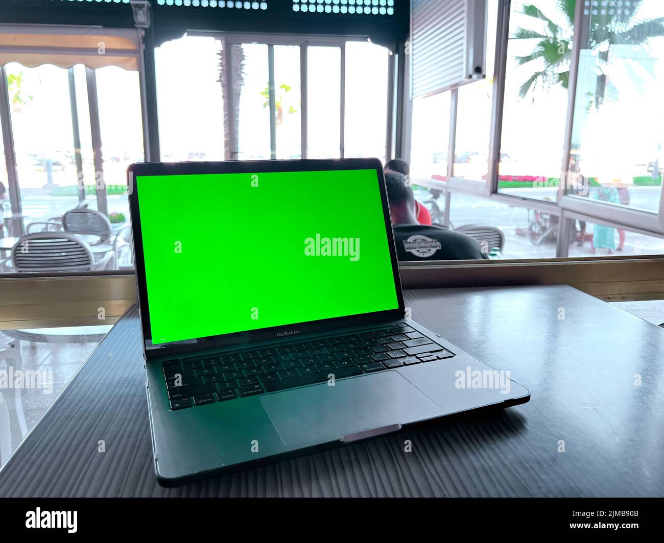 Une maquette d'ordinateur portable avec écran vert vierge sur la table Banque D'Images