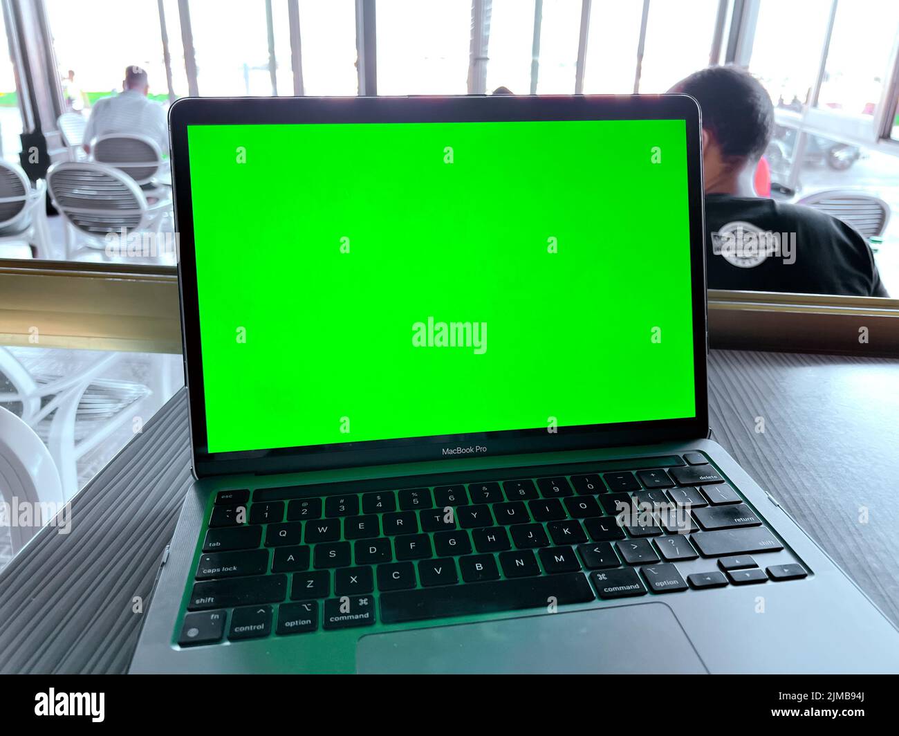 Une maquette d'ordinateur portable avec écran vert vierge sur la table Banque D'Images