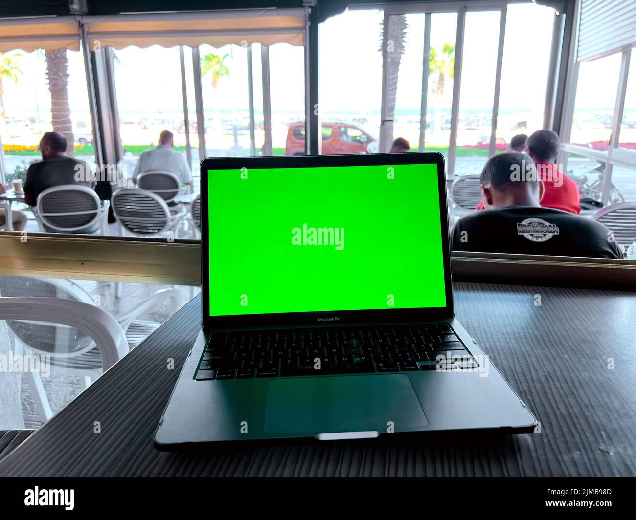 Une maquette d'ordinateur portable avec écran vert vierge sur la table Banque D'Images