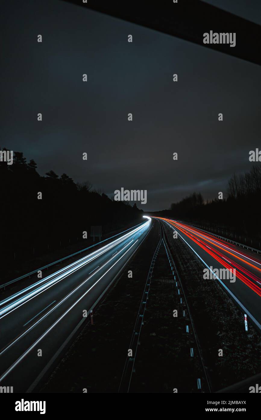 Une vue sur les sentiers de lumière sur la route pendant une nuit sombre Banque D'Images