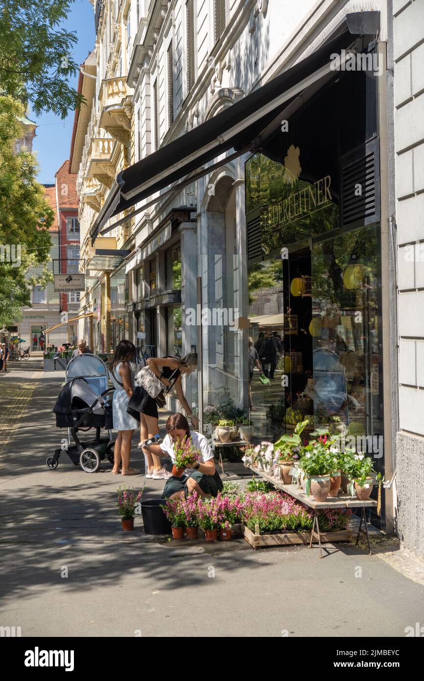 Un cliché vertical d'une femme caucasienne qui s'occupe de plantes devant un fleuriste à Graz, en Autriche Banque D'Images