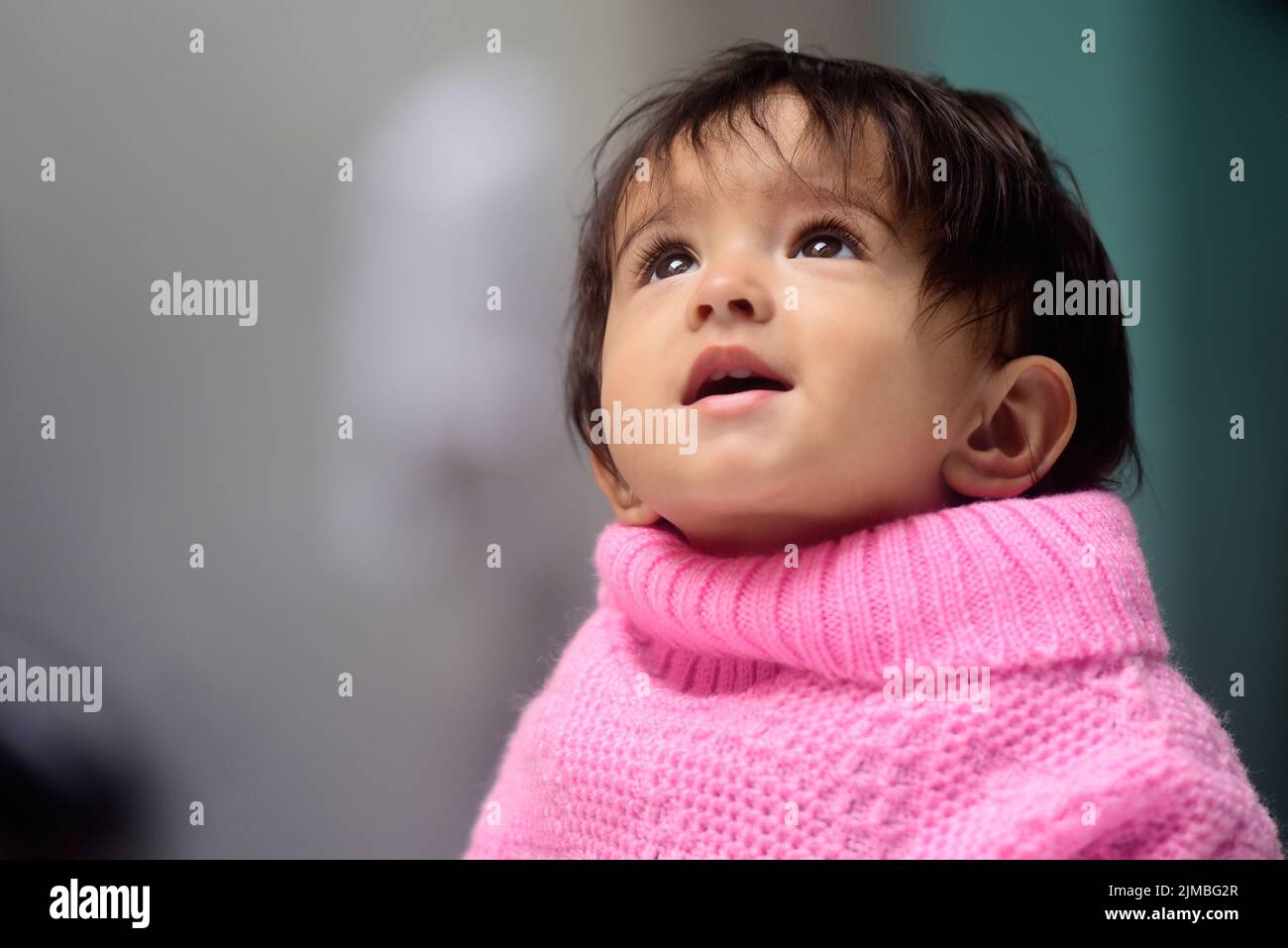 Une adorable petite fille indienne de 13 mois portant un poncho Banque D'Images