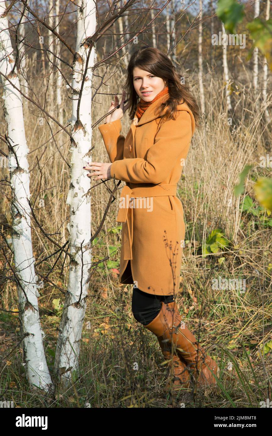 Jeune fille en automne parmi les jeunes arbres dans la forêt Banque D'Images