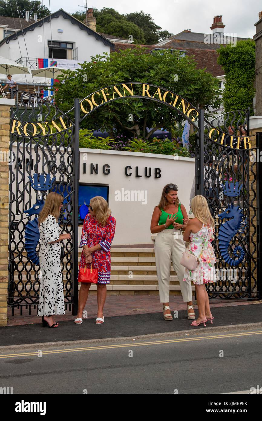 des femmes qui se tiennent ensemble pour discuter et discuter à l'entrée du club de course royal de l'océan pendant la régate de la semaine des cowes sur l'île de wight, jour des dames. Banque D'Images