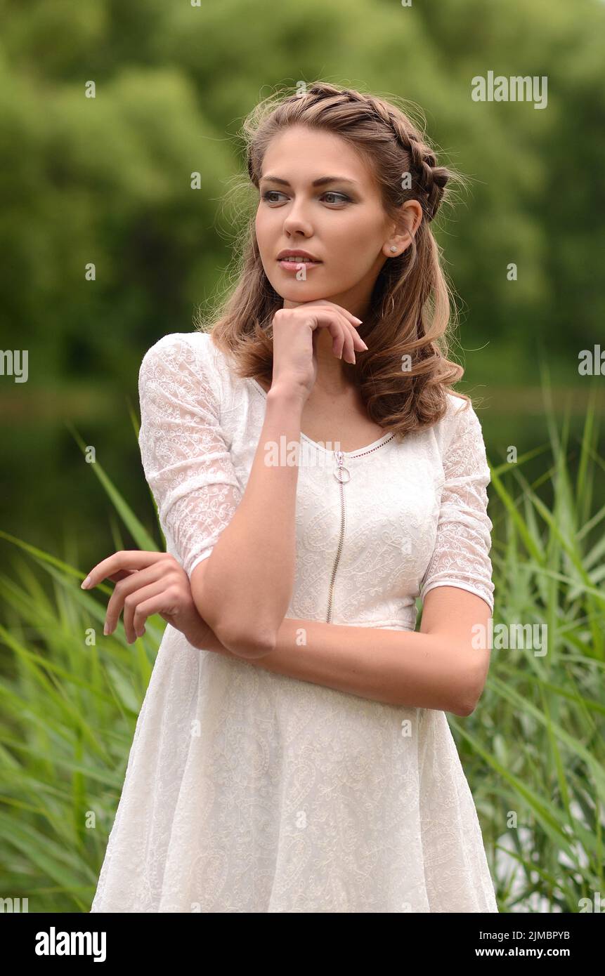 Belle naturelle jeune blonde femme souriante sur le terrain garder à la main des fleurs jaunes Banque D'Images