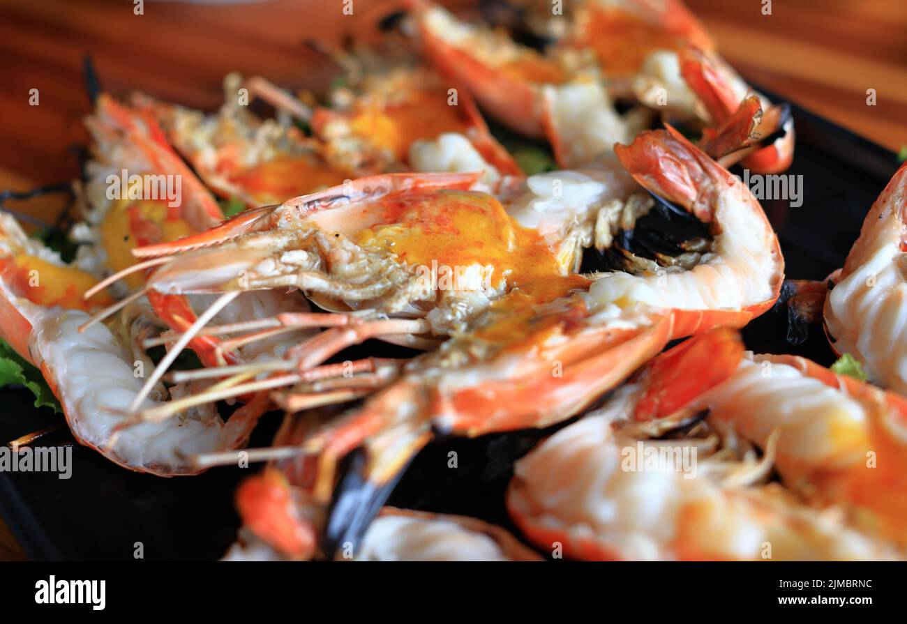 Gros plan sur la cuisine thaïlandaise, crevettes géantes fraîches grillées sur un grill traditionnel au charbon de bois, servies avec une sauce trempée épicée de style thaïlandais. Banque D'Images