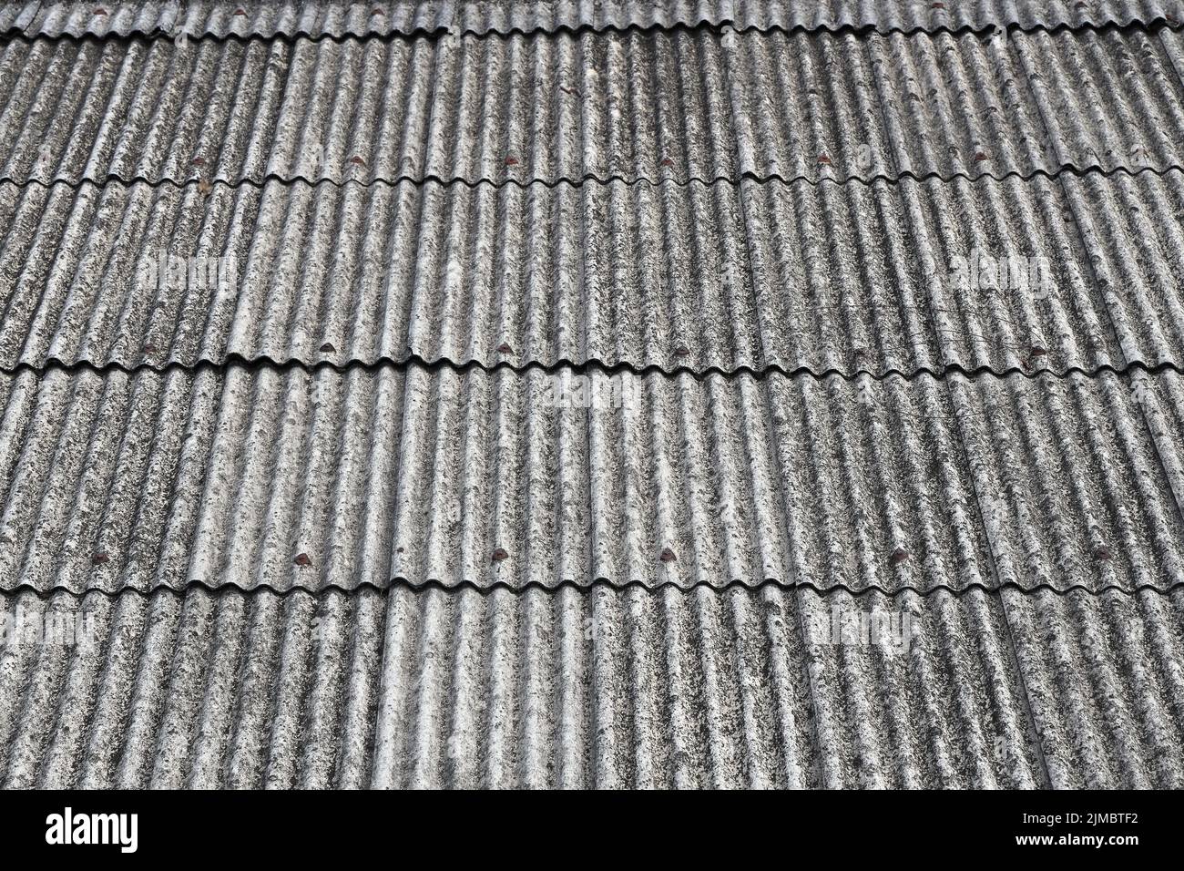 Anciennes feuilles de couverture en ciment d'amiante, toit en amiante, tôle de toit en ciment d'amiante ondulé, panneaux ondulés, texture ardoise grise, toit en ardoise ondulée grise. Banque D'Images