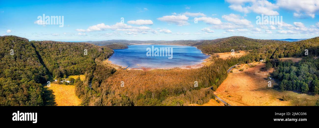 La route des lacs autour du lac Myall Parc national en Australie avec fermes agricoles dans les bois de gommiers - panorama aérien. Banque D'Images
