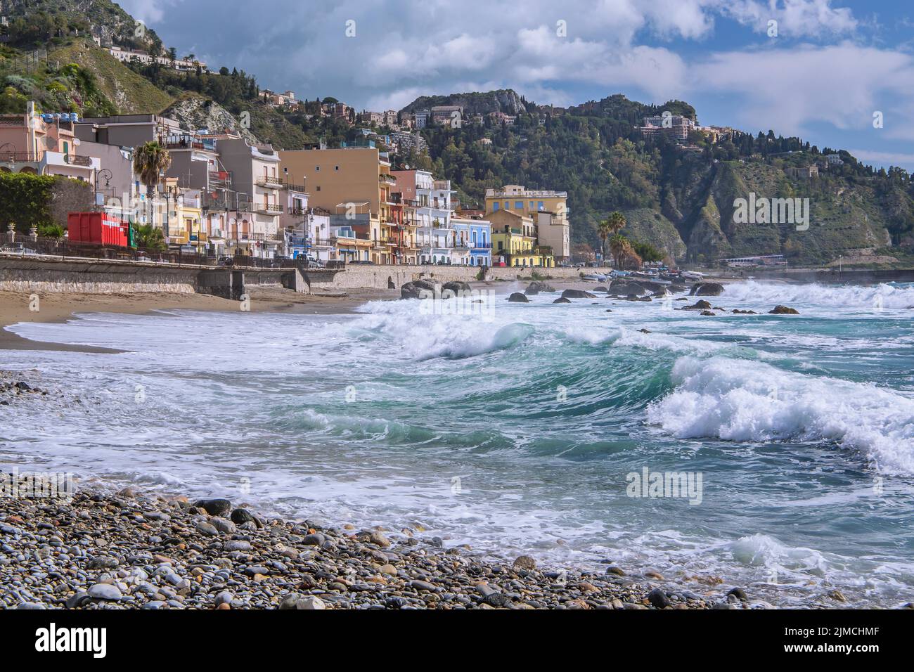 Surf en bord de mer en face de la promenade avec Taormina sur la colline, Giardini-Naxos, côte est, Sicile, Italie Banque D'Images