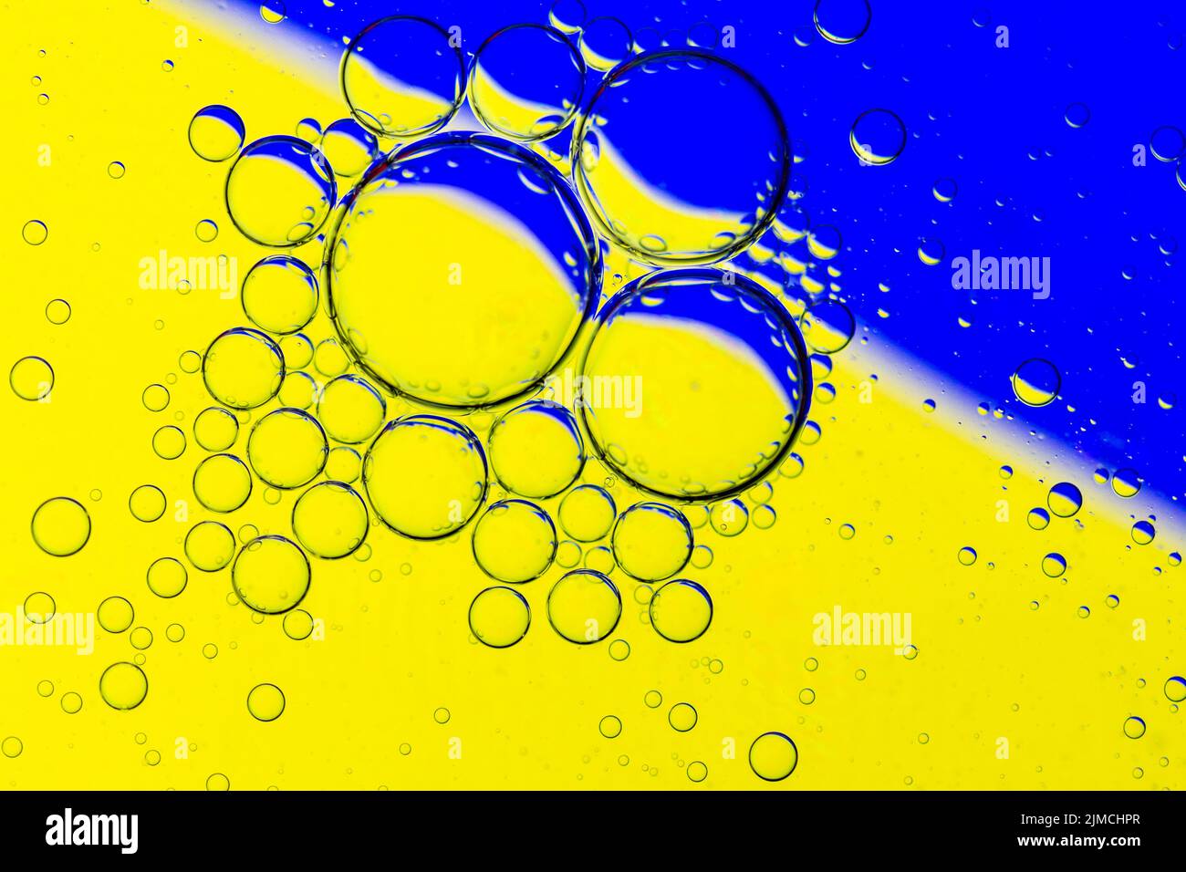 Résumé fond des bulles d'huile sur la surface de l'eau jaune bleu palette colorée. Banque D'Images