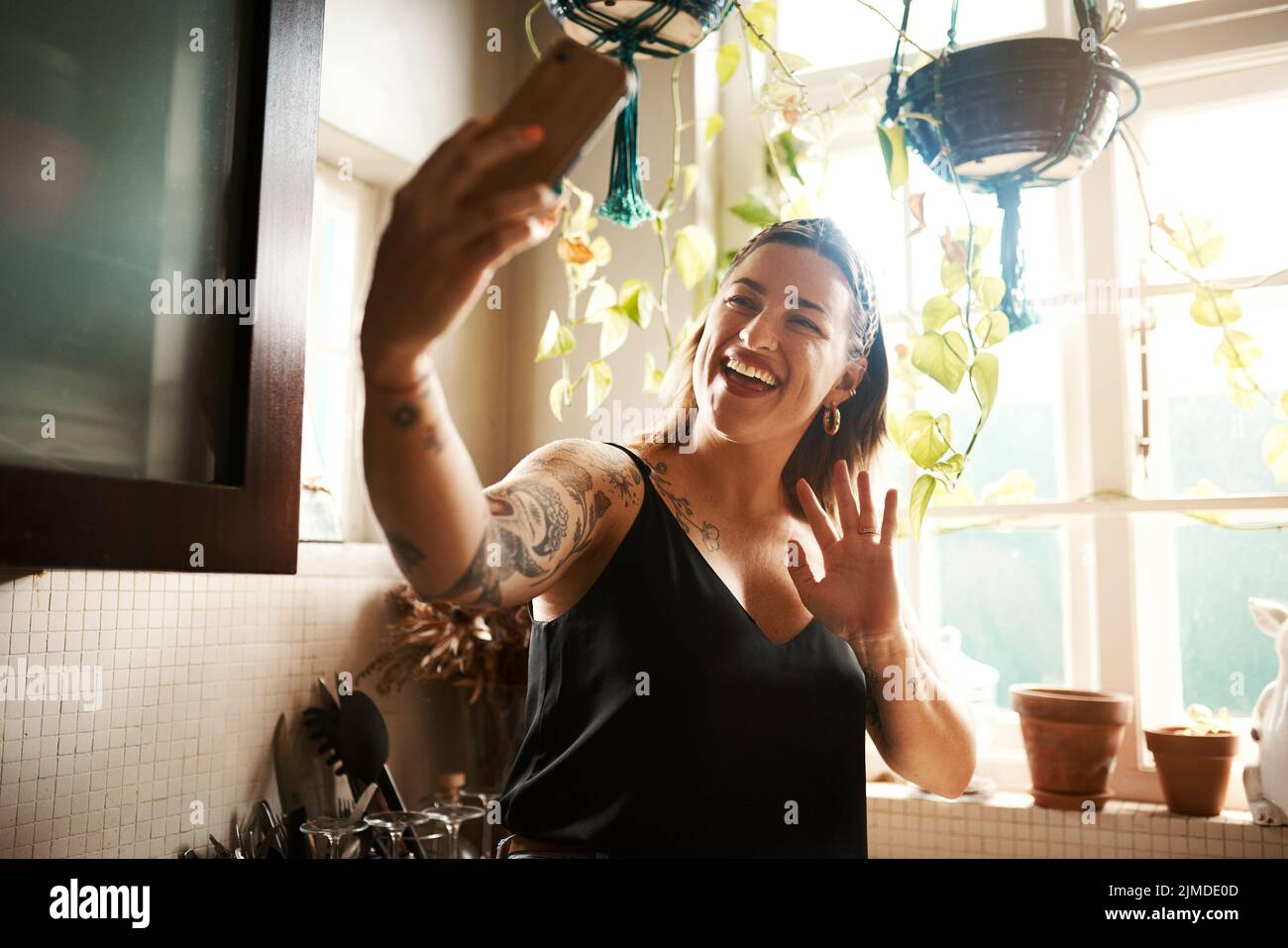 Parler lors d'un appel vidéo téléphonique, faire des signes et saluer tout en communiquant, en discutant et en réseau pendant le verrouillage. Femme souriante, heureuse et gaie ou Banque D'Images