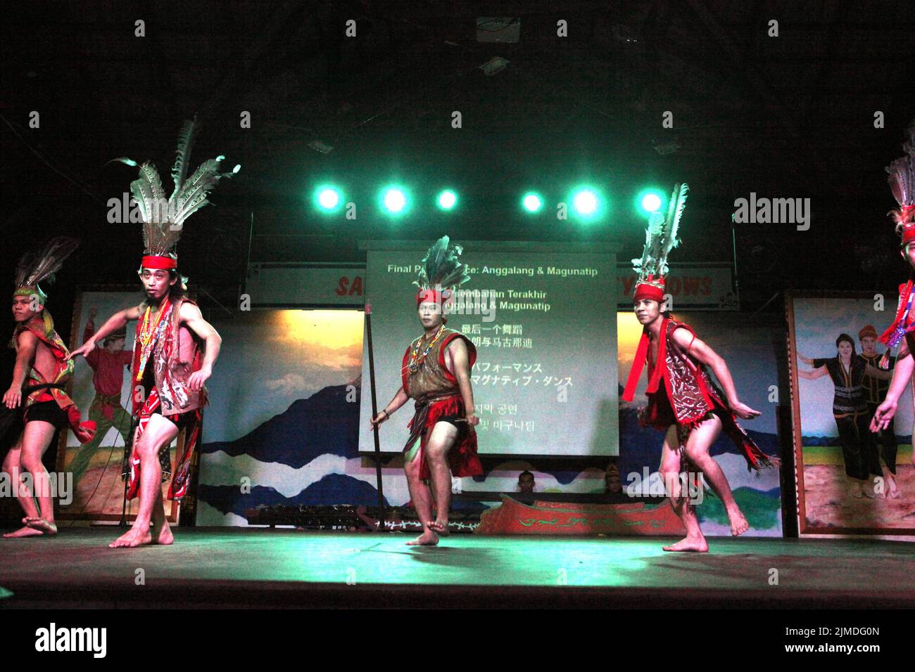 Les hommes portant une tenue traditionnelle Dayak exécutent une danse du groupe sous-ethnique Murut appelé Anggalang & Magunatip à Kampung Nelayan, un restaurant de fruits de mer à Kota Kinabalu, en Malaisie. Banque D'Images