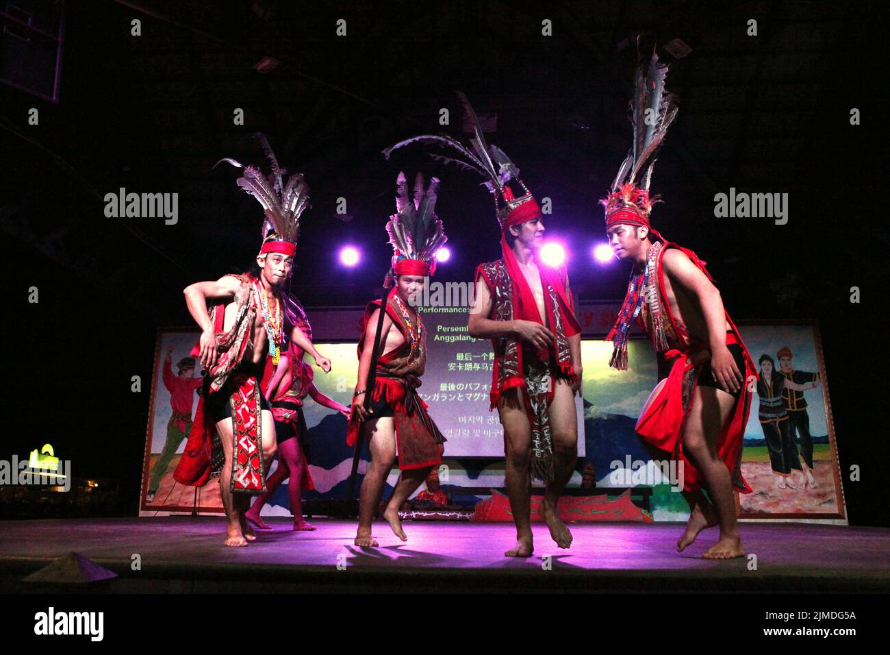 Les hommes portant une tenue traditionnelle Dayak exécutent une danse du groupe sous-ethnique Murut appelé Anggalang & Magunatip à Kampung Nelayan, un restaurant de fruits de mer à Kota Kinabalu, en Malaisie. Banque D'Images