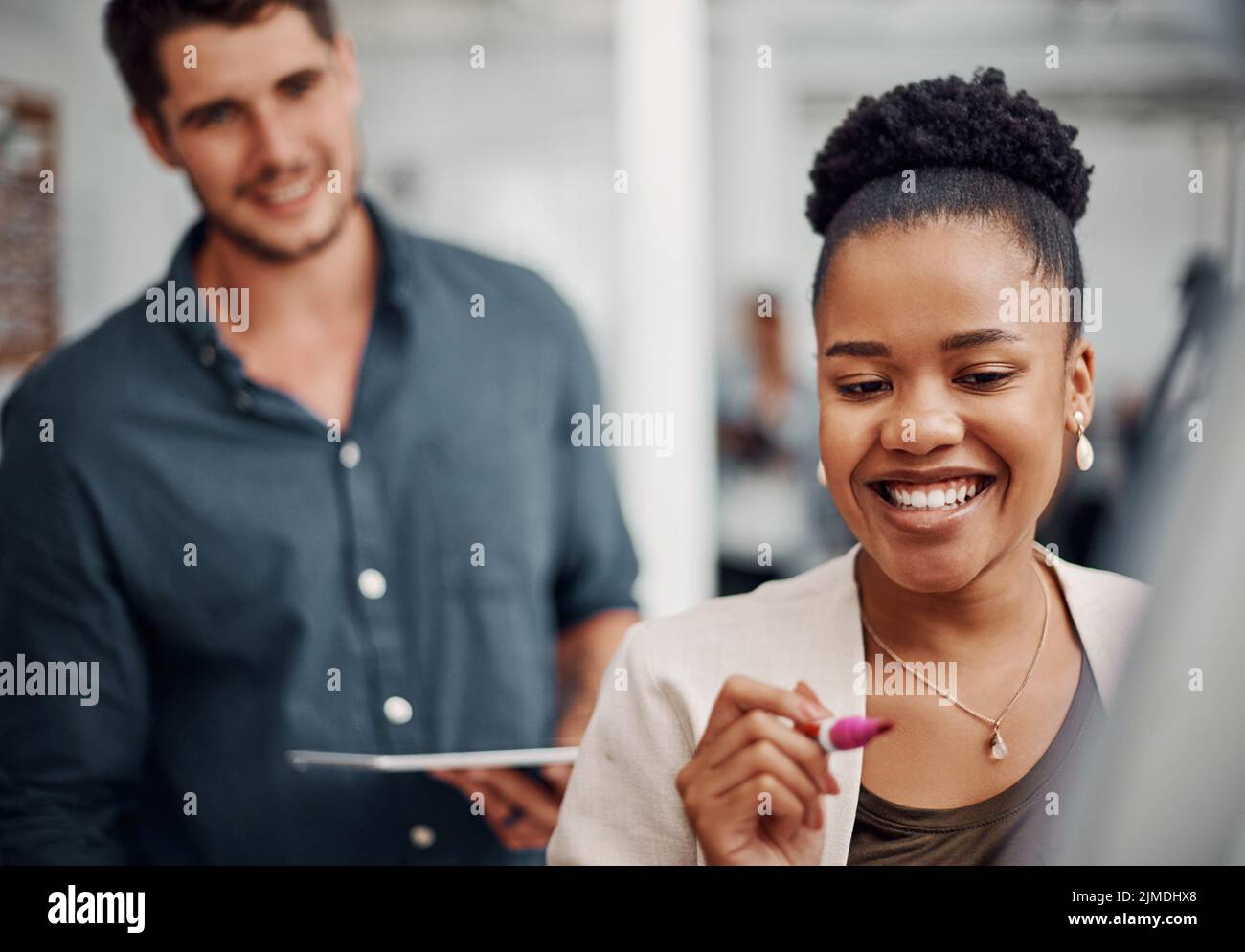 La créativité met le meilleur d'eux-mêmes. Une jeune femme d'affaires attirante utilisant une aide visuelle pour faire du brainstorming avec ses collègues au bureau. Banque D'Images