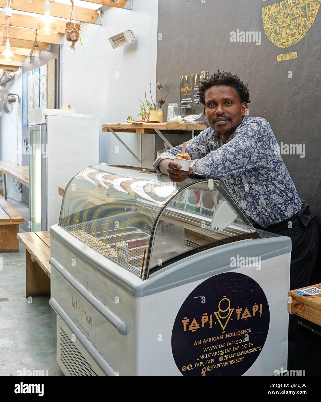 Kapstadt, Afrique du Sud. 26th juillet 2022. Tapiwa Guzha se trouve dans son glacier TAPI TAPI. Le biologiste moléculaire a inventé plus de 600 variétés de glace inhabituelles dans la métropole touristique du Cap. Tapiwa Guzha aime jouer avec de nouvelles combinaisons de saveurs. (À dpa 'poisson et argile: Curieuse tendance de la glace au Cap') Credit: Kristin Palitza/dpa/Alamy Live News Banque D'Images