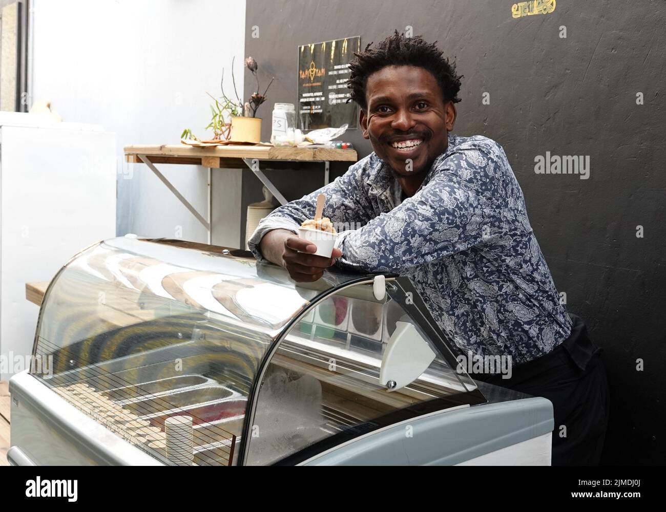 Kapstadt, Afrique du Sud. 26th juillet 2022. Tapiwa Guzha se trouve dans son glacier TAPI TAPI. Le biologiste moléculaire a inventé plus de 600 variétés de glace inhabituelles dans la métropole touristique du Cap. Tapiwa Guzha aime jouer avec de nouvelles combinaisons de saveurs. (À dpa 'poisson et argile: Curieuse tendance de la glace au Cap') Credit: Kristin Palitza/dpa/Alamy Live News Banque D'Images