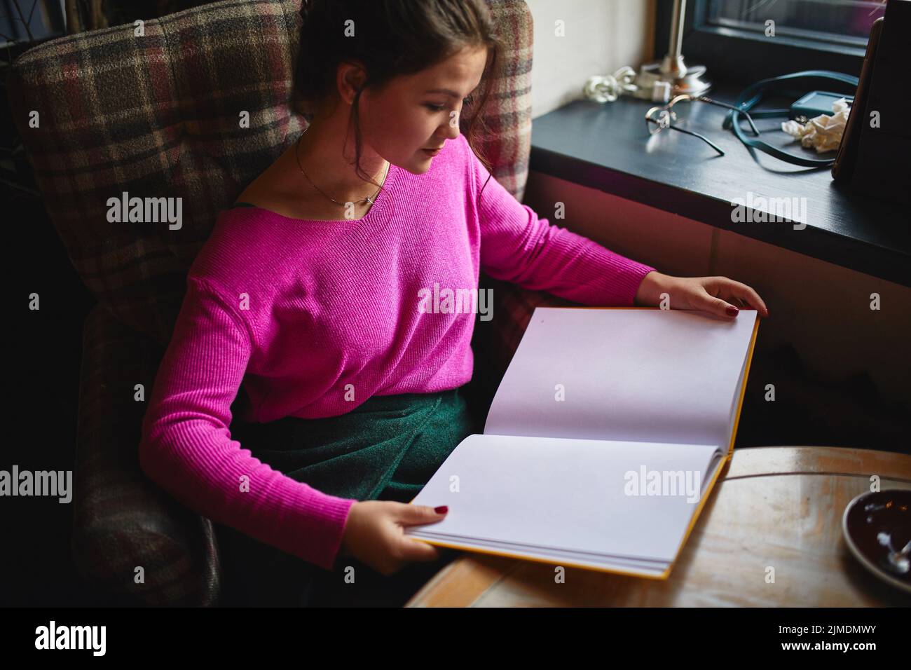 Assez jeune femme lisant le menu dans le café Banque D'Images