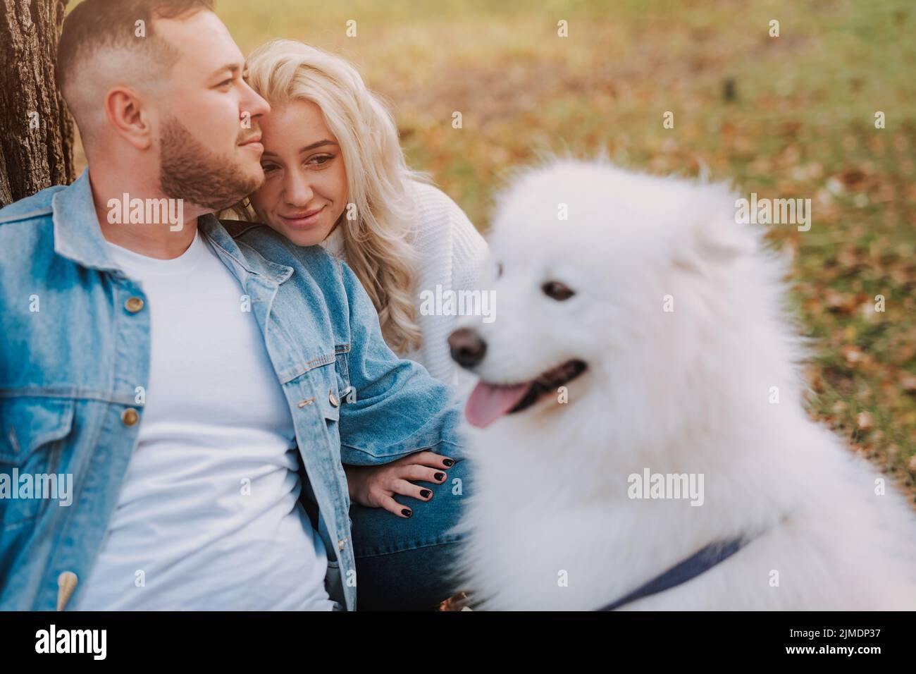 Un couple avec un chiot de race samoyed profite de son week-end Banque D'Images