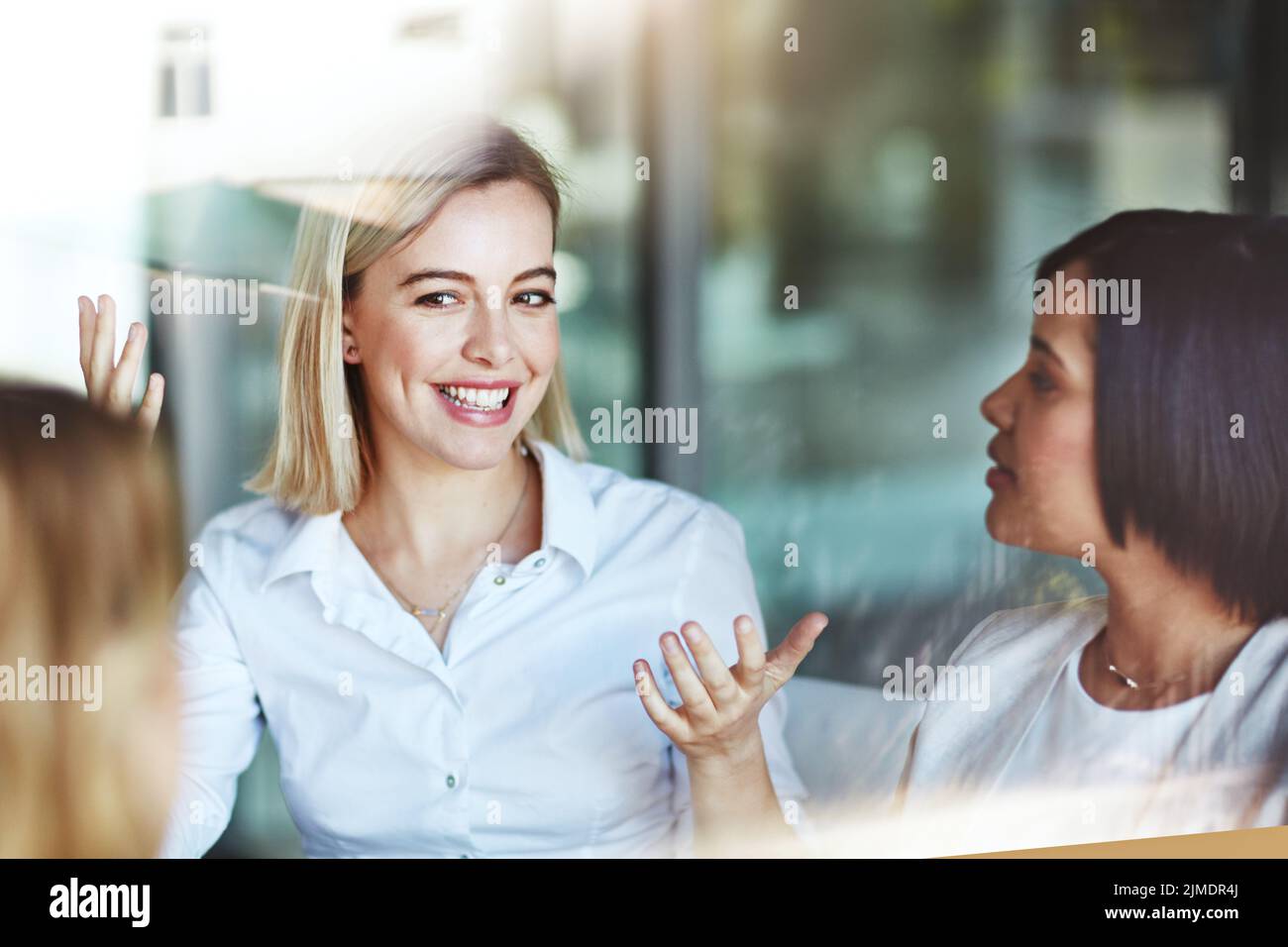 Une employée de bureau en pause avec des collègues parlant et ayant une conversation au travail. Les professionnels passent du temps ensemble à l'intérieur. Sourire Banque D'Images