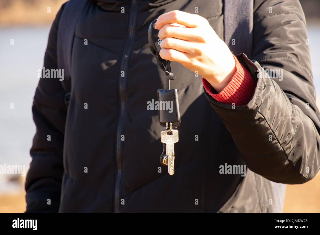 la fille tient dans ses mains les clés de l'appartement sur la rue au soleil, les clés de la maison, l'achat et la location de biens immobiliers Banque D'Images