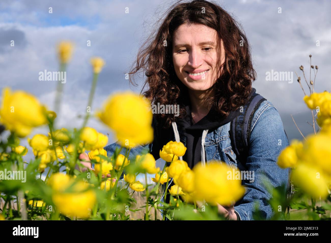 Fille et fleurs jaunes. Sortir de la ville. Faune. Heure d'été. Banque D'Images